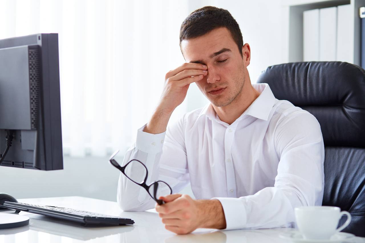 man rubbing eyes